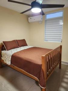 莱维顿Encanto Caribeño en Levittown Lakes Puerto Rico的卧室内的一张床位,配有吊扇
