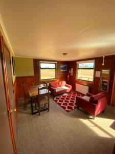 百内三塔廷德尔湖山林小屋的客厅配有红色家具和桌子