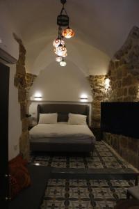 阿卡Shafika house的一间卧室配有一张床和一个吊灯
