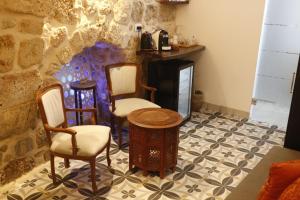 阿卡Shafika house的一间设有两把椅子、一张桌子和一个壁炉的房间