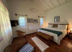 库穆鲁沙蒂巴Pousada Villa Cumuru的一间卧室配有一张床和一把椅子