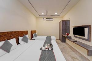 新德里Hotel Bellwood Grand Near Delhi IGI Airport的配有一张床和一台平面电视的酒店客房