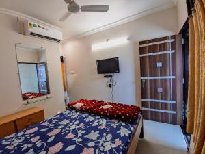 曼德维HK Inn的一间带床和电视的小卧室