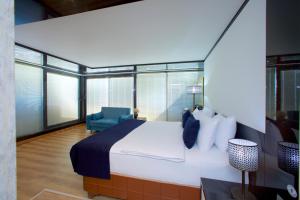 伊斯坦布尔The Hera Platinum Hotel的一间卧室配有一张大床和一张蓝色椅子