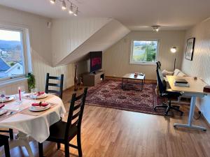 NeseFjord-View Apartment的一间带餐桌的客厅和一间客厅。