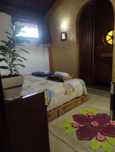 索罗卡巴Hospedagem San Gonzales的一间卧室设有两张床和盆栽植物