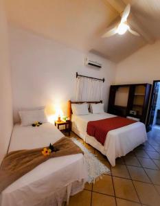 库穆鲁沙蒂巴Pousada Villa Cumuru的一间卧室配有两张床和一张带台灯的桌子