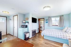 GraylandBreakwater Inn - Shoalwater Cottage #E的一间拥有蓝色墙壁的卧室,配有一张床和一张桌子