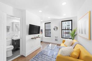 纽约69-4B Modern Lower East Side 1BR PRIME LOCATION的客厅设有黄色沙发和电视