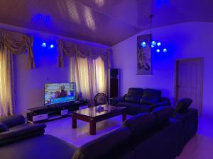 阿克拉AGASTEV Guesthouse GH的紫色的客厅配有沙发和电视
