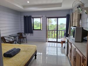 涛岛Phonsomboon Guesthouse的客房设有床、电视和阳台。