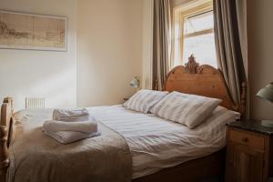 SnaithThe Plough Inn的一间卧室配有一张带白色床单的床和一扇窗户。