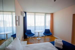 巴统Welcome To Batumi的一间卧室配有两张桌子和两张蓝色椅子