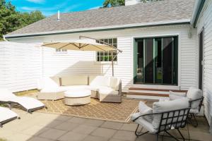 Westhampton BeachCasa Hermes in Hamptons的庭院配有白色家具和雨伞。