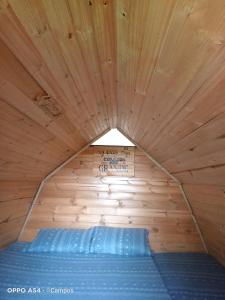 蒙圭CASA BAHAREQUE HOSPEDAJE的木制客房的一张床位,设有木制天花板