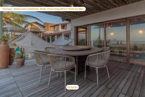 泰巴Casa Desert Point com piscina vista mar por Tactu的露台设有木桌和椅子,甲板上设有