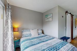 GraylandBreakwater Inn - Bulfinch Condo #5的一间卧室配有一张带蓝色和白色棉被的床