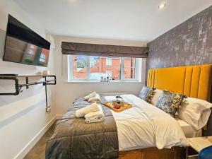 切尔滕纳姆Cobblestone Studio的一间卧室配有一张带黄色床头板的大床