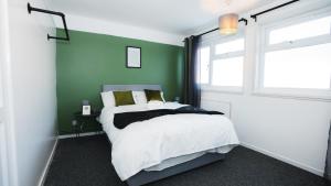 伦敦1 Bed Flat Tottenham Hale N17的一间卧室配有一张带绿色墙壁的床