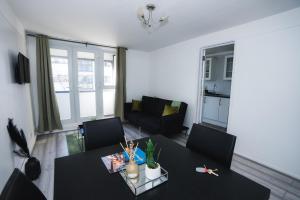 伦敦1 Bed Flat Tottenham Hale N17的客厅配有黑色的桌子和椅子