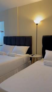 安格拉杜斯雷斯Pousada Himura的酒店客房,设有两张床和一盏灯