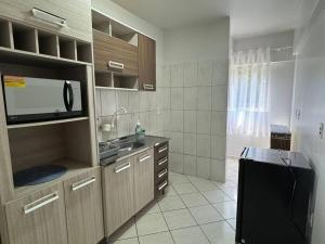 弗朗西斯科贝尔特朗Apartamento com mobília nova 301的厨房配有水槽和微波炉