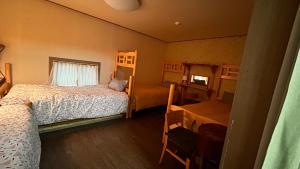 庆州Gyeongju Momojane Guesthouse的一间卧室设有两张床、一张桌子和一个窗口