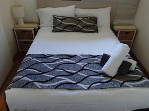 福斯特福斯特和瓦利斯湖汽车旅馆的一张配有黑白床单和枕头的床