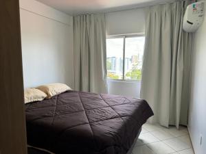 弗朗西斯科贝尔特朗Apartamento com mobília nova 301的一间卧室设有一张床和一个大窗户