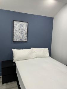 巴塞尔顿Everlight Basildon House的卧室配有白色床和蓝色墙壁