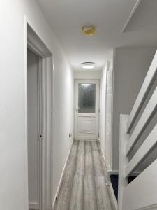 巴塞尔顿Everlight Basildon House的一条空的走廊,有白色的门和楼梯