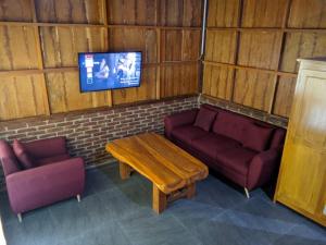 SorongjukungTahlia's Villa的客房设有两张沙发、一张桌子和一台电视机。
