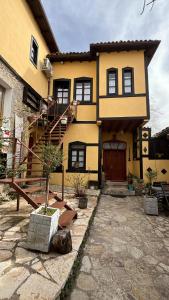 克鲁亚ROOMS EMILIANO Castle of Kruja的黄色的房子,前面有楼梯