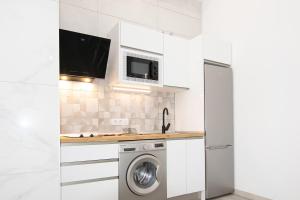 埃尔泰勒罗The Safe Point Suites Tablero的白色的厨房配有洗衣机和烘干机