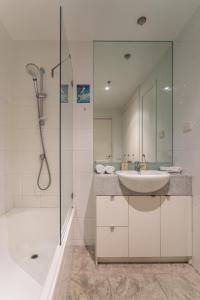 墨尔本IMSA集团公寓的白色的浴室设有水槽和淋浴。