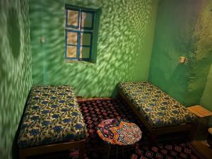 阿斯旺Humble Nubia的绿色的客房设有两张床和窗户。