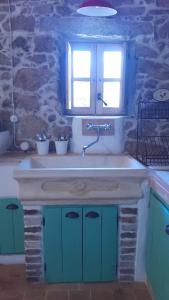 蒙蒂holiday home su Niberalzu的厨房设有水槽,窗户位于石墙内