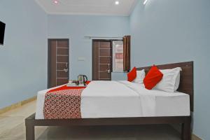 斋浦尔Flagship Hotel Ansh Plaza的一间卧室配有一张带红色枕头的大床