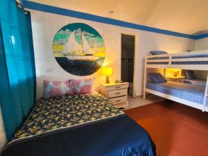 普拉亚科罗纳多Las Catalinas Coronado的卧室配有两张双层床,墙上挂着帆船