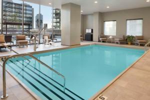 芝加哥Hampton Inn by Hilton Chicago Downtown West Loop的酒店大堂的游泳池,配有桌椅