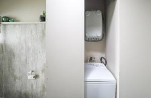 罗托鲁瓦Hannah's Bay Lakefront的一间带卫生间的浴室和架子上的电话