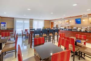 查尔斯顿Comfort Inn & Suites Airport Convention Center的一间带桌椅的餐厅和一间酒吧