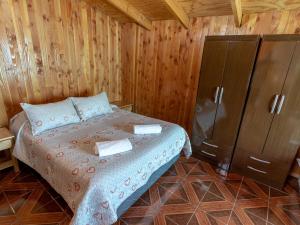 普孔Hotel Catripulli的木制客房内的一间卧室,配有一张床