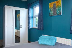 CorrofinRiverside Cottage in the Burren的蓝色的卧室设有床和窗户
