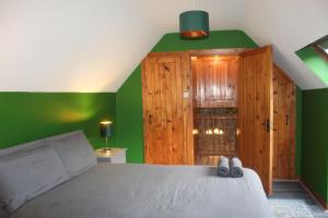 CorrofinRiverside Cottage in the Burren的一间拥有绿色墙壁的卧室和一张带鞋的床