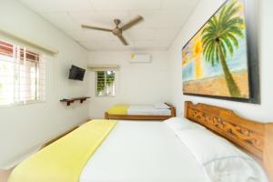 托卢Hostal del Mar - Tolu的卧室配有一张床,墙上挂有绘画作品