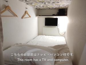 大阪Cafe&Hostel きみといちご的配有电视和床的房间
