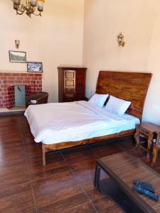 乌提Heritage Inn by Brown Tree Resorts的一间卧室配有一张大床和一张桌子