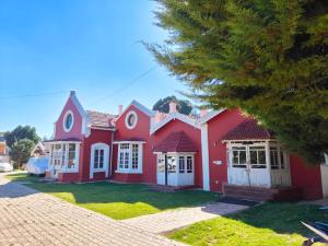 乌提Heritage Inn by Brown Tree Resorts的院子里有白色门的红色房子
