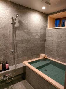 仓敷吉井日式旅馆的设有带浴缸和淋浴的浴室。